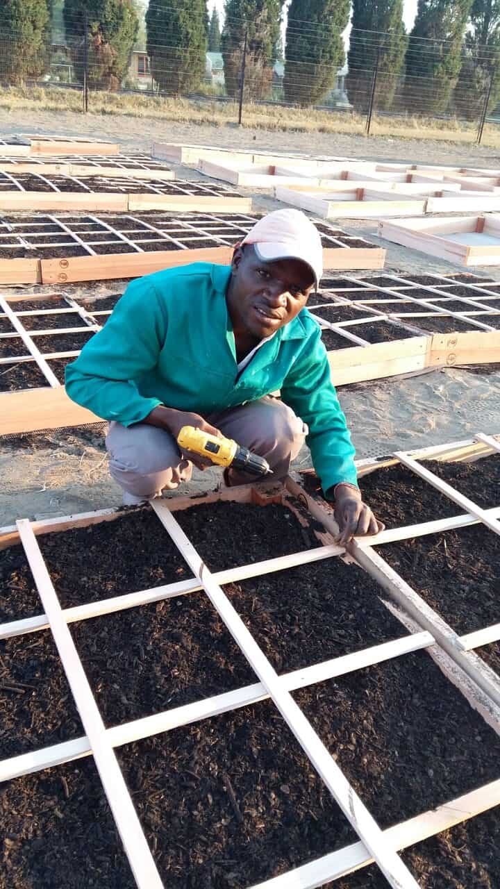 man is building square foot garden in South Africa